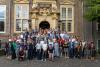 An open-air group photo of the participants of the environmental law conference at the stairs of the main entrance of the conference venue in Utrecht.